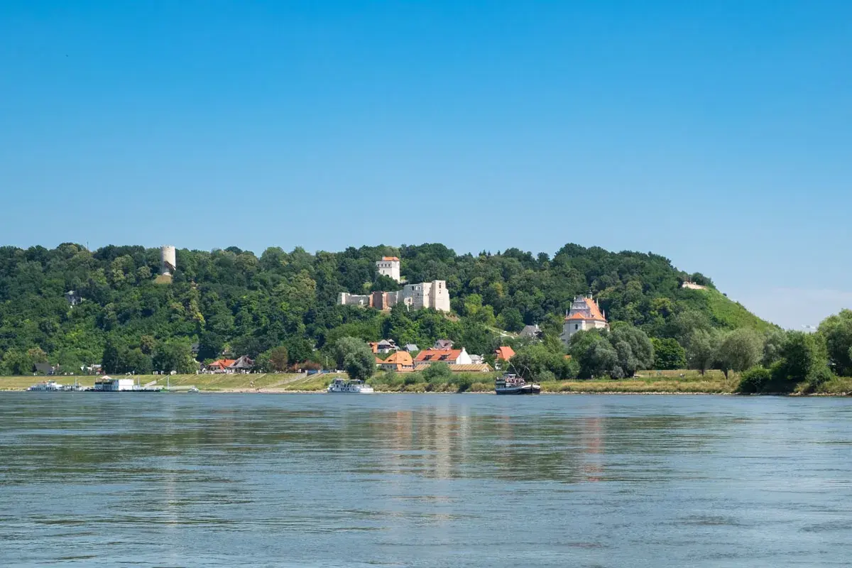 Widok na Wisłę i wzgórza z ruinami zamku, wieżą i kościołem. Kazimierz Dolny atrakcje zachwycają o każdej porze roku.